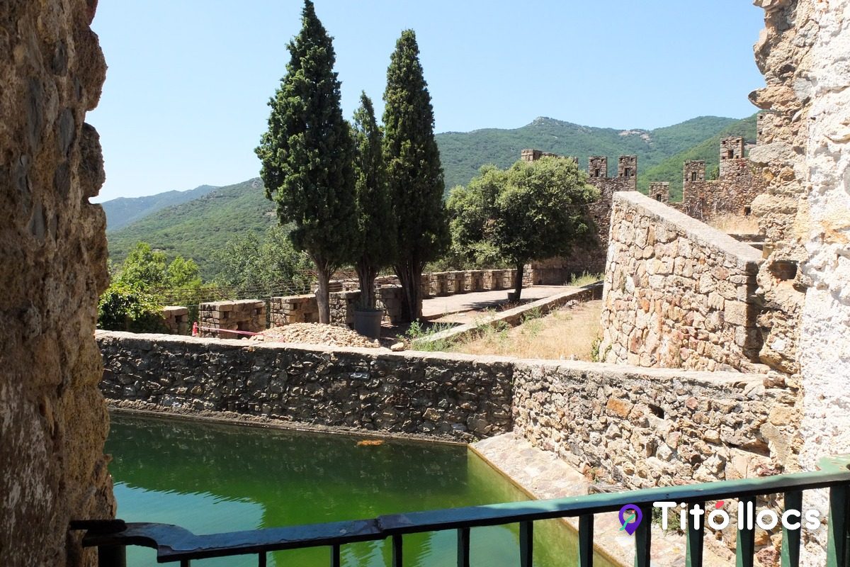 El pati interior del castell amb la bassa d'aigua i els xiprers