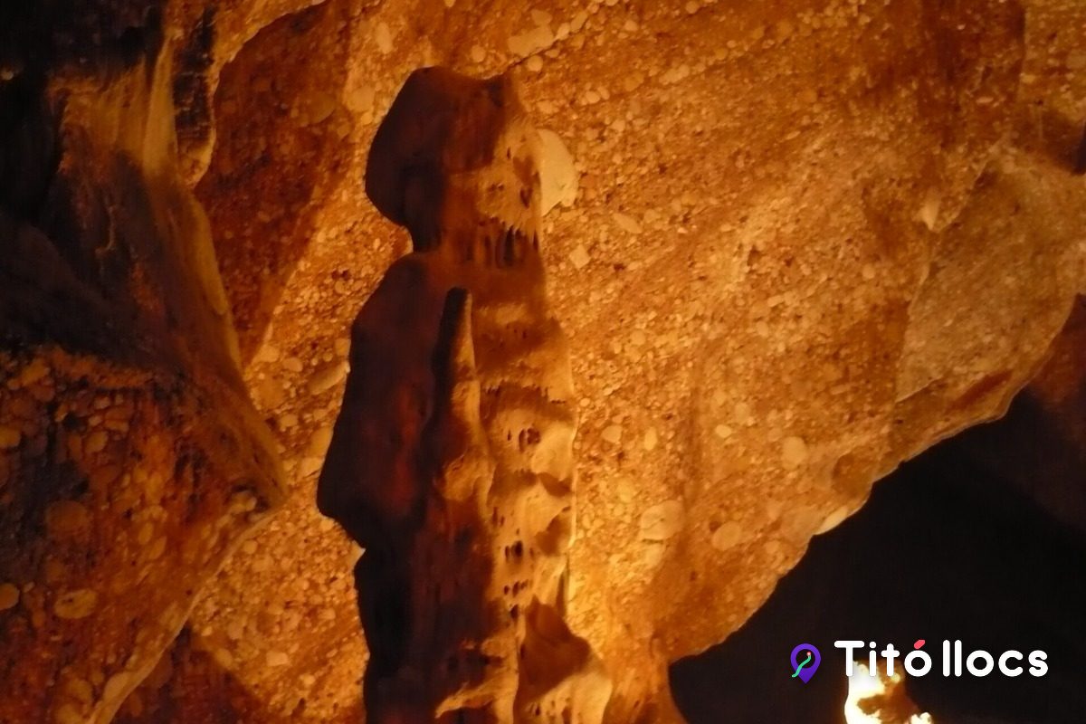 Una gran columna de pedra il·luminada a l'interior de les Coves del Salnitre