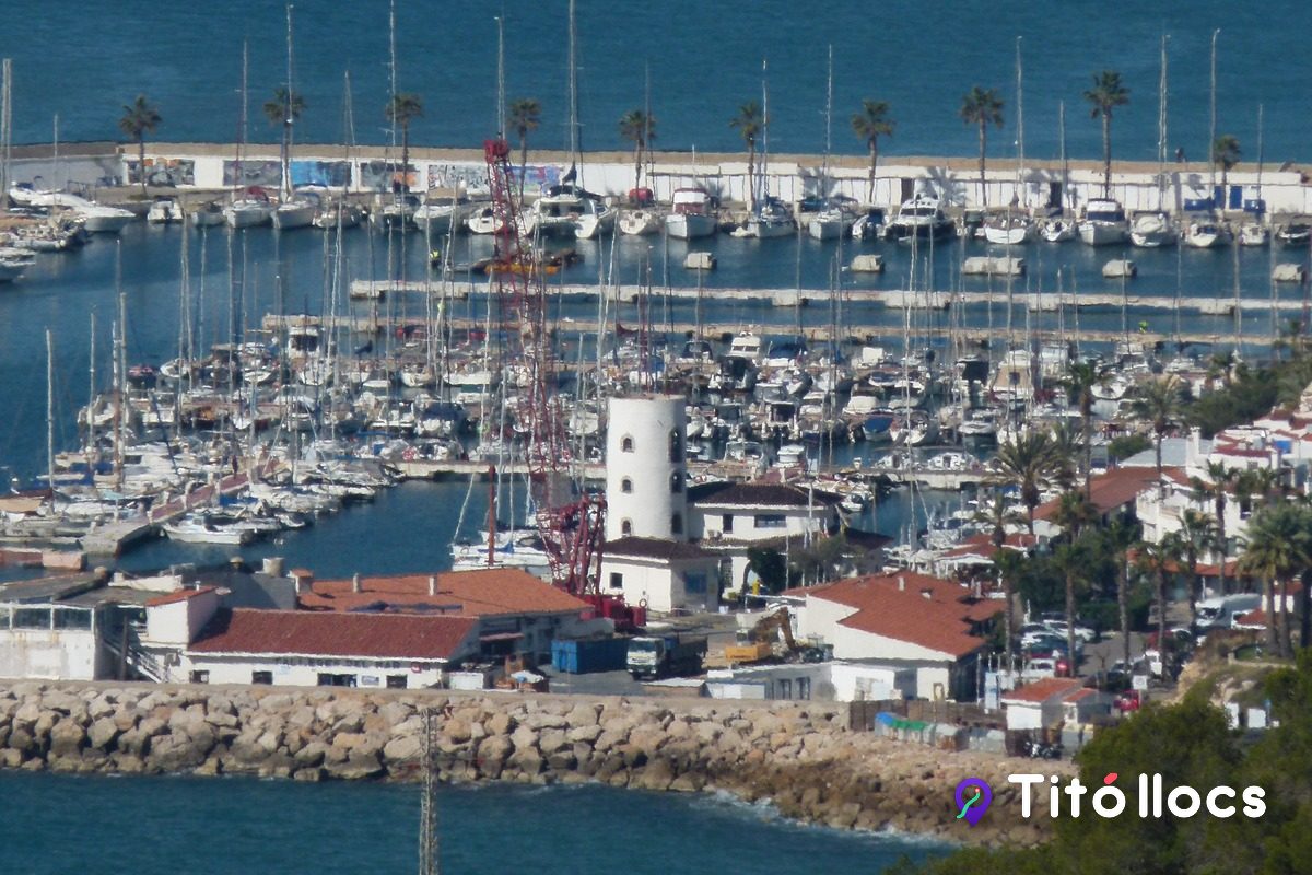 El port d'Aiguadolç de Sitges, amb el far i els vaixells, vist des d'un turó