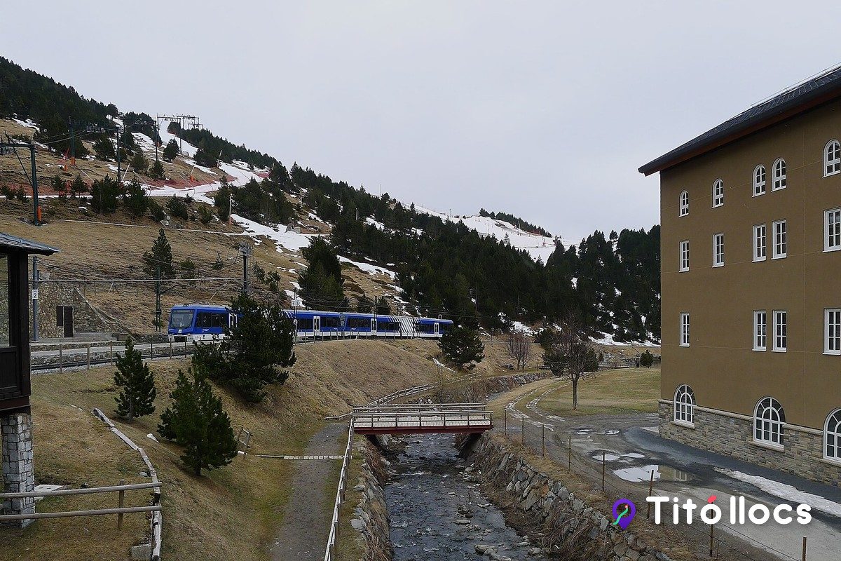 L'edifici de l'hotel i l'estació de muntanya de la Vall de Núria, amb les pistes al darrere
