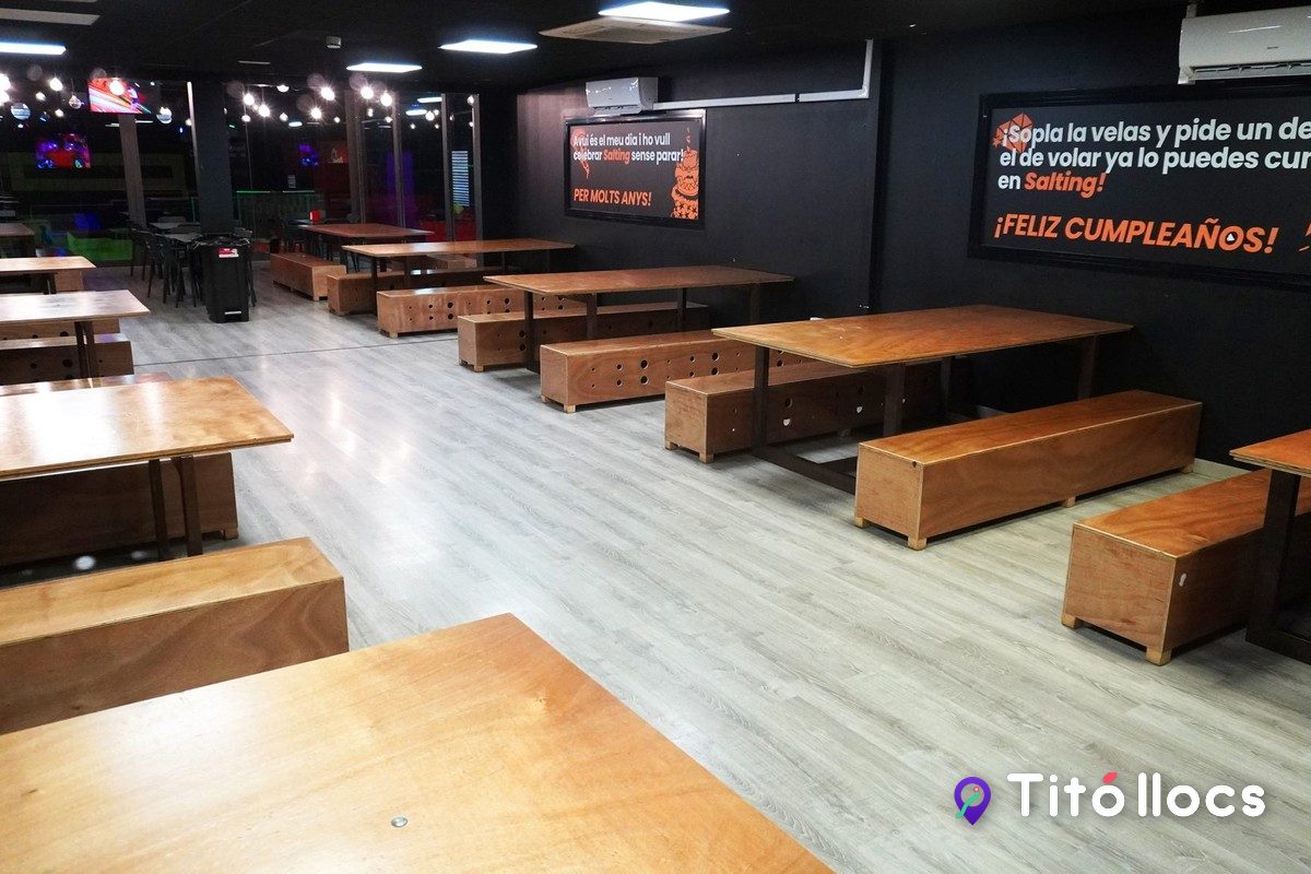 La zona d'aniversaris del Salting Granollers, amb taules de fusta i bancs per a grups