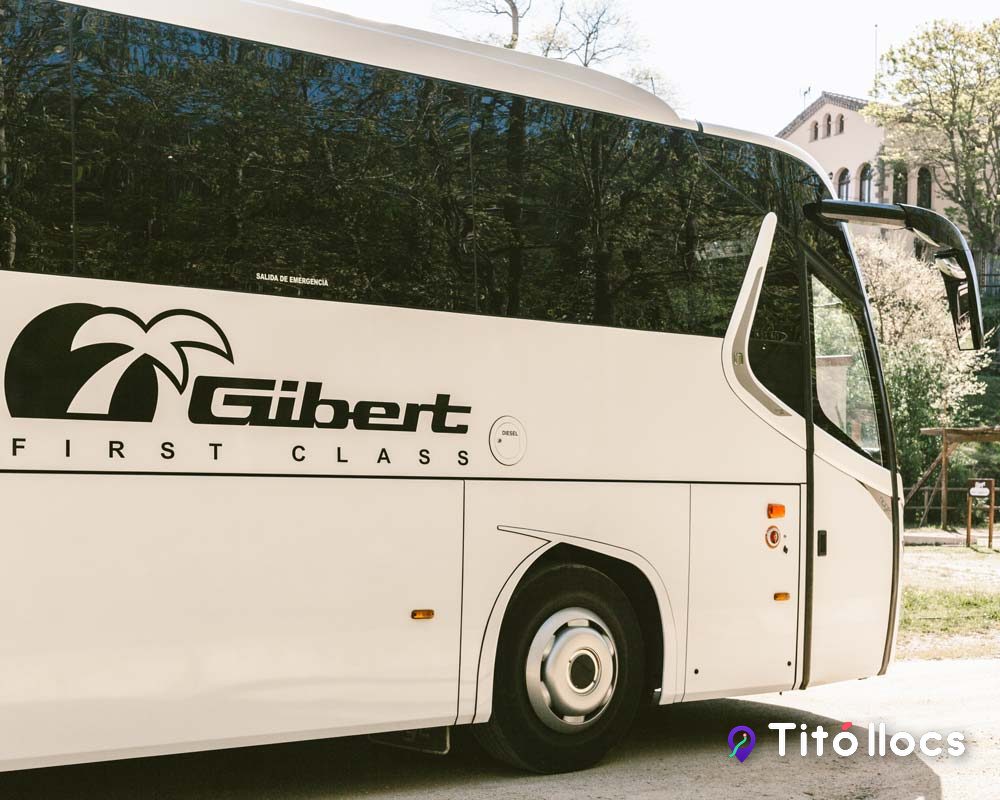Autocar blanc de Gibert amb el rètol First Class, a Vilanova del Vallès