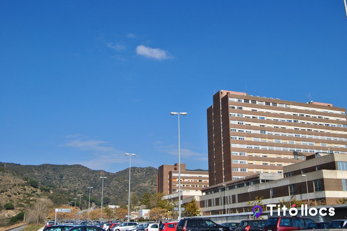 Torre de l'hospital Germans Trias i Pujol vista des de l'aparcament, amb vehicles i fanals