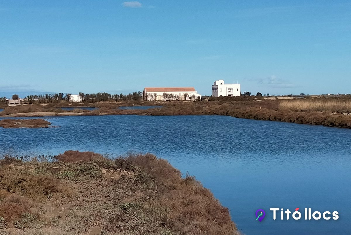 Bassa de les salines amb els edificis del Delta al fons, a MónNatura Delta de l'Ebre
