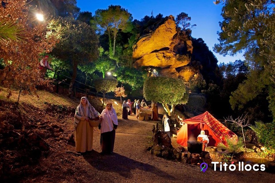 Figures amb vestits d'època pel camí il·luminat del recinte, al Pessebre Vivent de Corbera de Llobregat