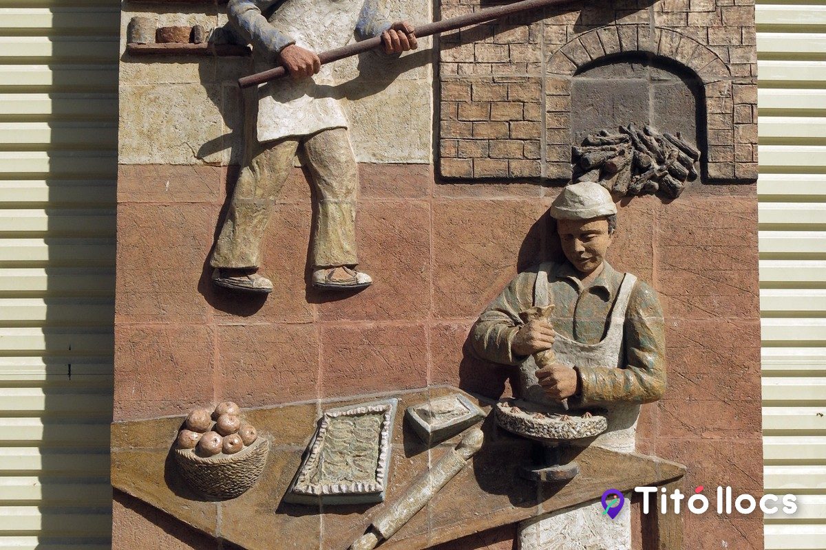Relleu ceràmic de la fleca Peretó amb dos forners treballant, a la plaça de la Creu de Torà