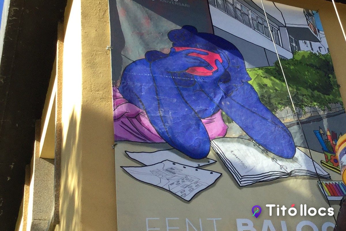 Detall del mural Fent Baloo, la pota d'un os amb un pinzell davant d'un quadern obert, a l'Escola Baloo de Montbau