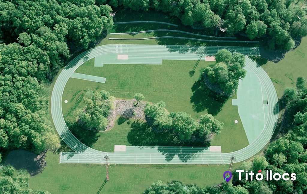 Vista zenital de la pista d'atletisme envoltada de bosc de roures, a l'Estadi Tossols-Basil d'Olot