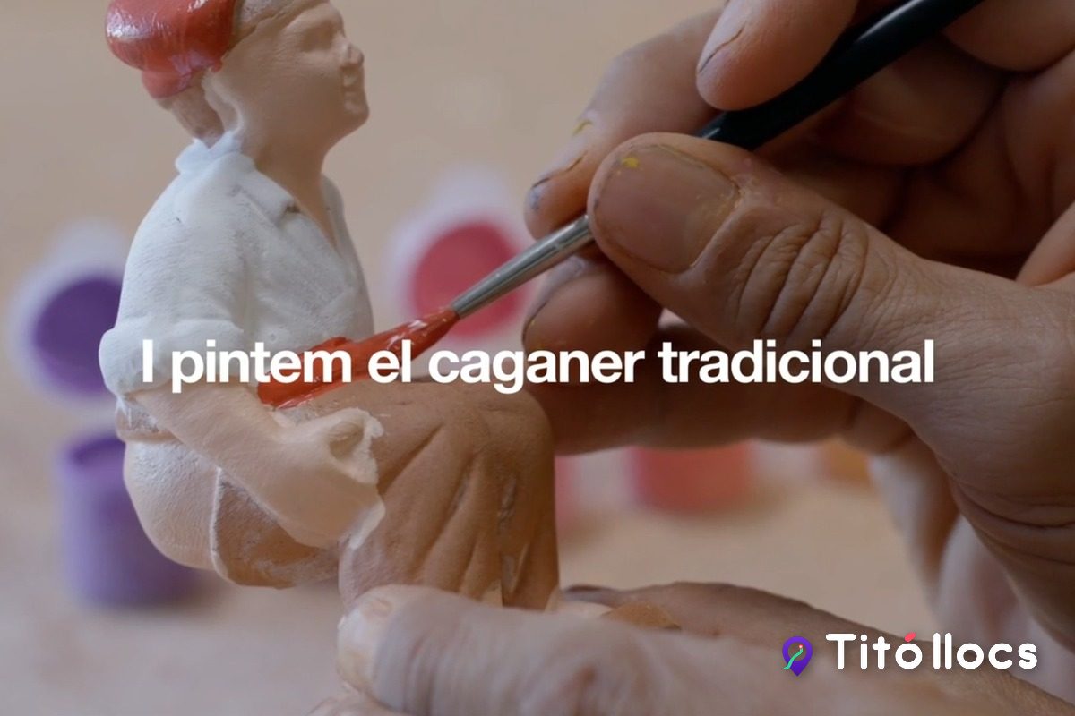 Mans pintant amb un pinzell un caganer de fang tradicional, amb els pots de pintura al fons, a Caganer.com