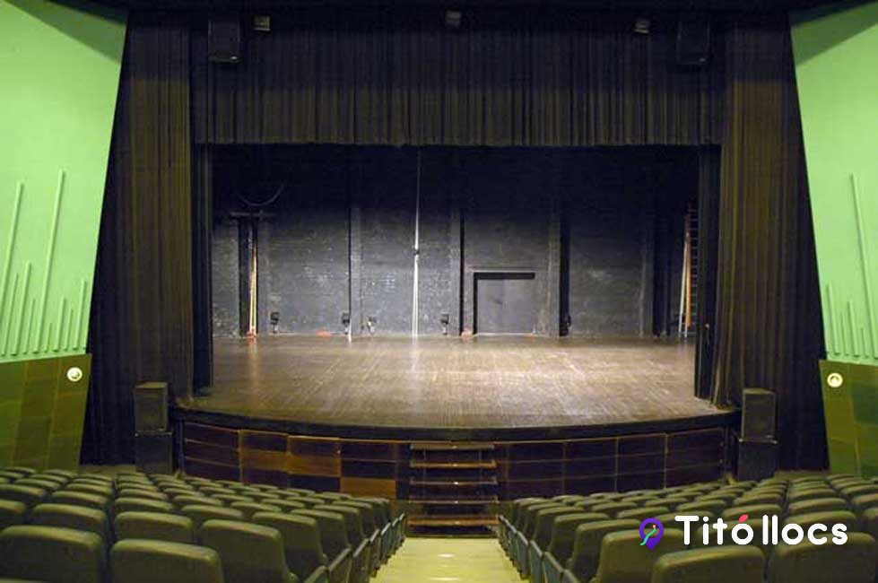La sala principal amb les butaques verdes i l'escenari, al Teatre Cirvianum
