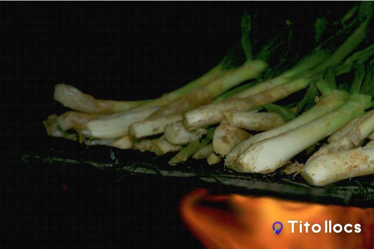 Calçots couant sobre la graella amb flama de sarments a la Masia del Pla