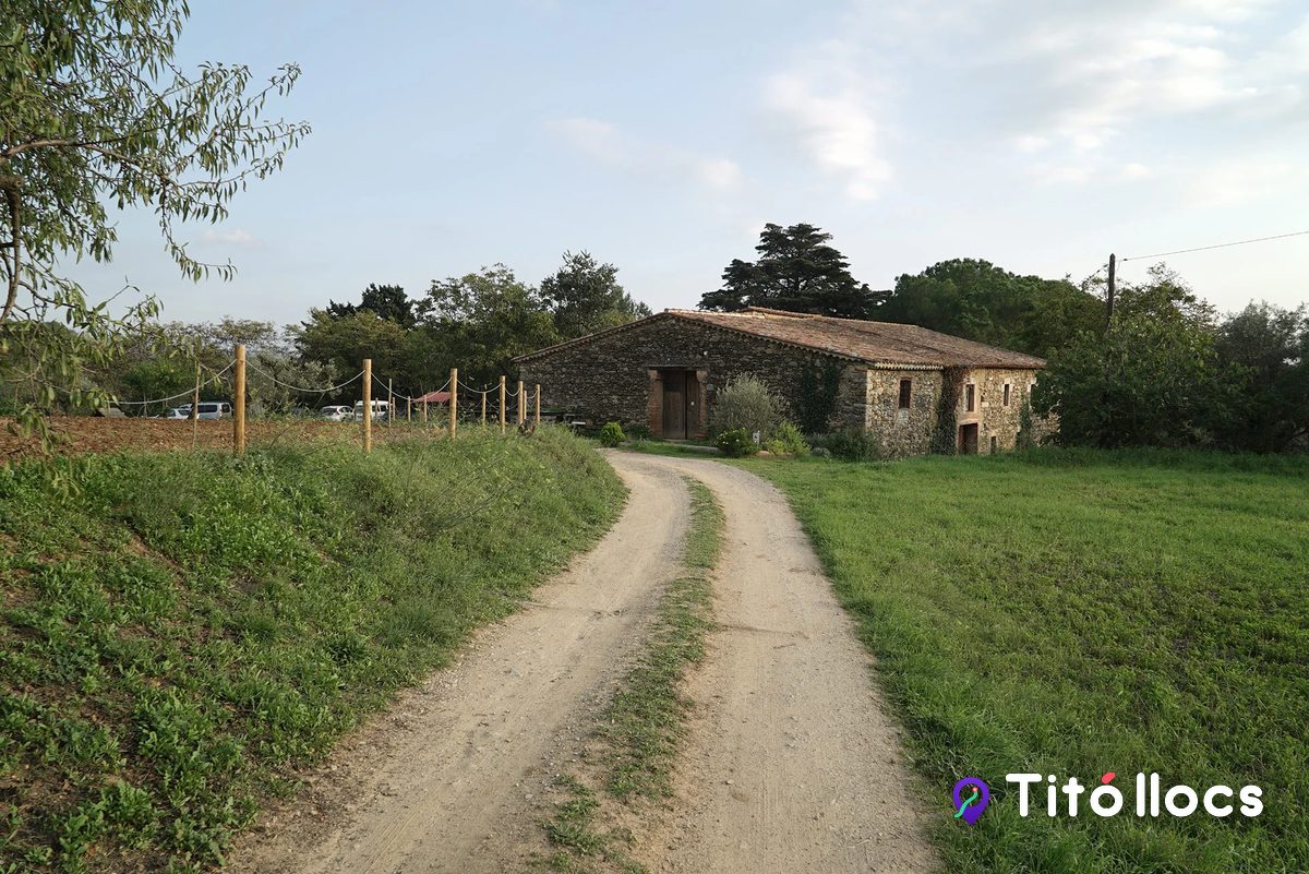El camí de terra que puja cap a la masia de pedra d'HORTUS, amb la tanca de corda i els camps a banda i banda, a Can Samon (Cànoves i Samalús)