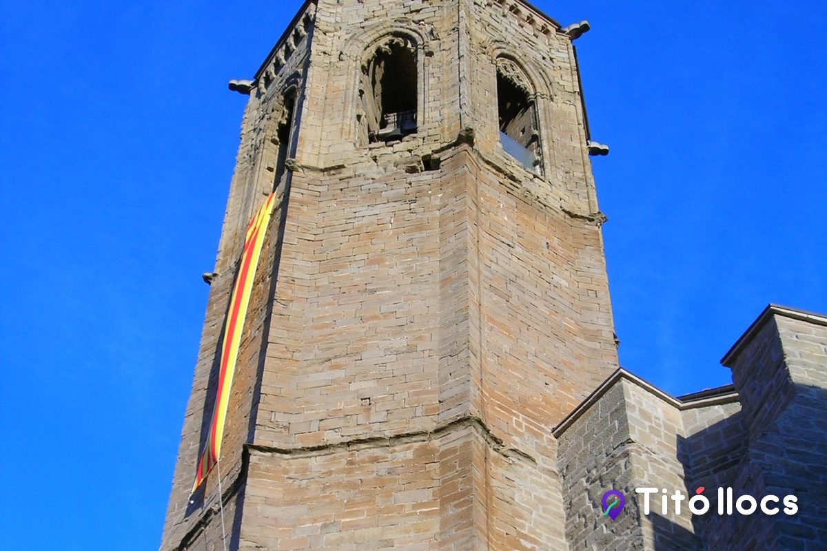 El campanar de Santa Maria de Cervera vist de prop, amb les banderes onejant al costat