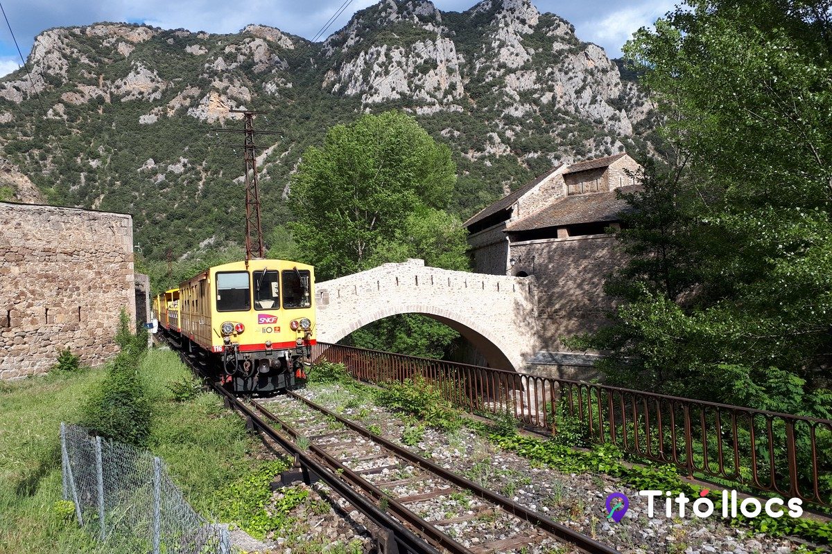 El Tren Groc creuant el pont de pedra als peus de la fortalesa de Vilafranca de Conflent