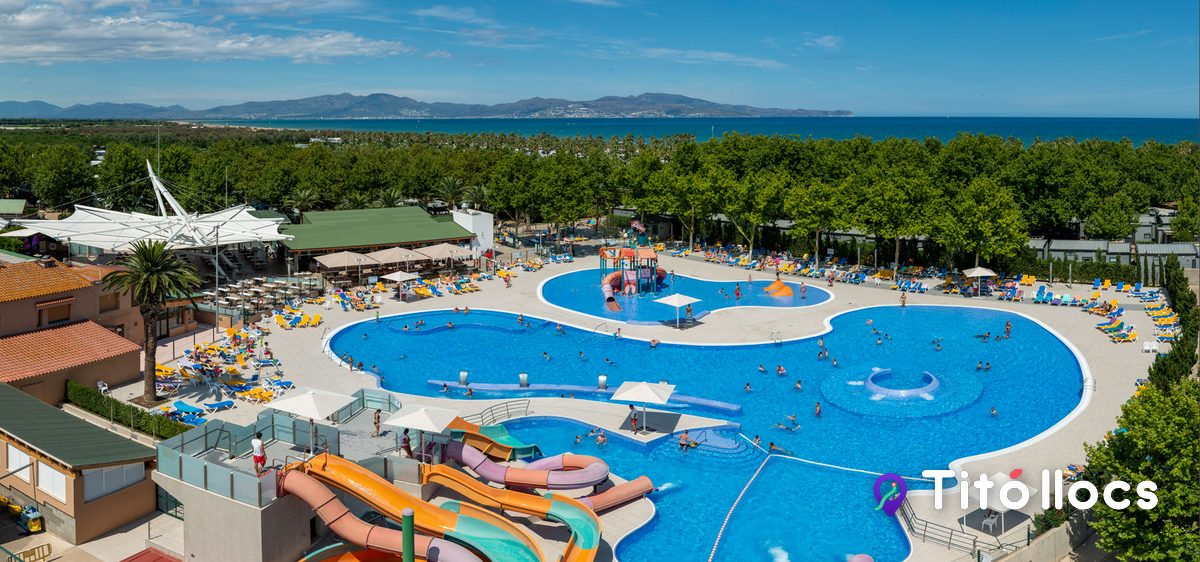 El parc aquàtic del Camping Las Dunas, amb tobogans i piscines i la badia de Roses al fons