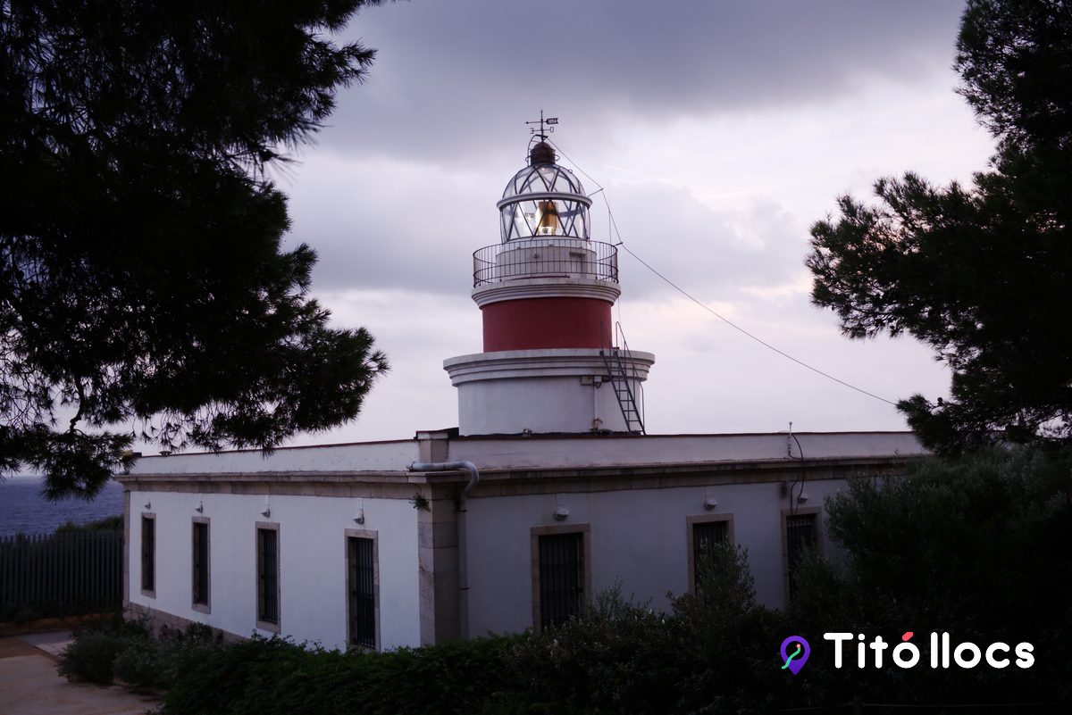 Torre del far de Salou amb la franja vermella sota la galeria, amb núvols al darrere