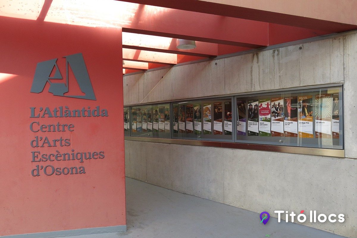 Panell vermell amb el logotip de L'Atlàntida i els cartells de la programació, a Vic