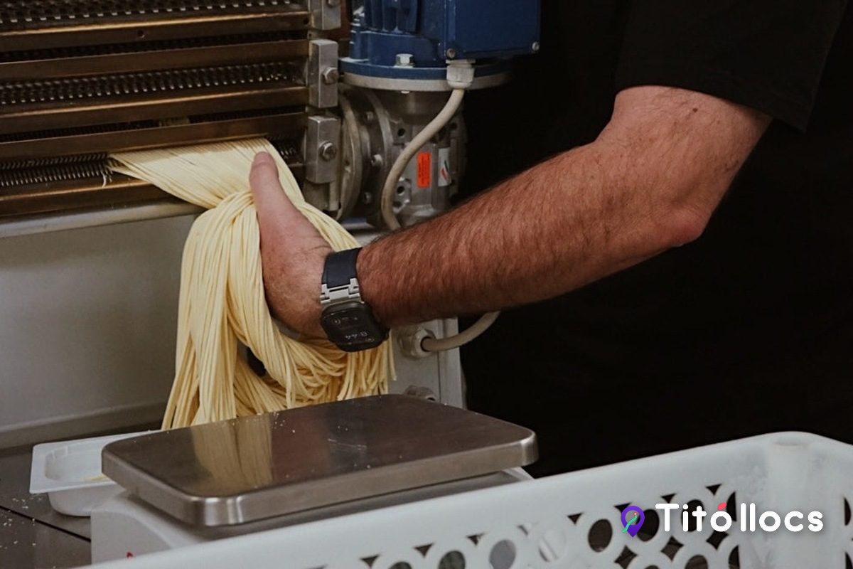 Tallarines fresques sortint de la màquina de pasta de l'obrador, a La Italiana Rivali
