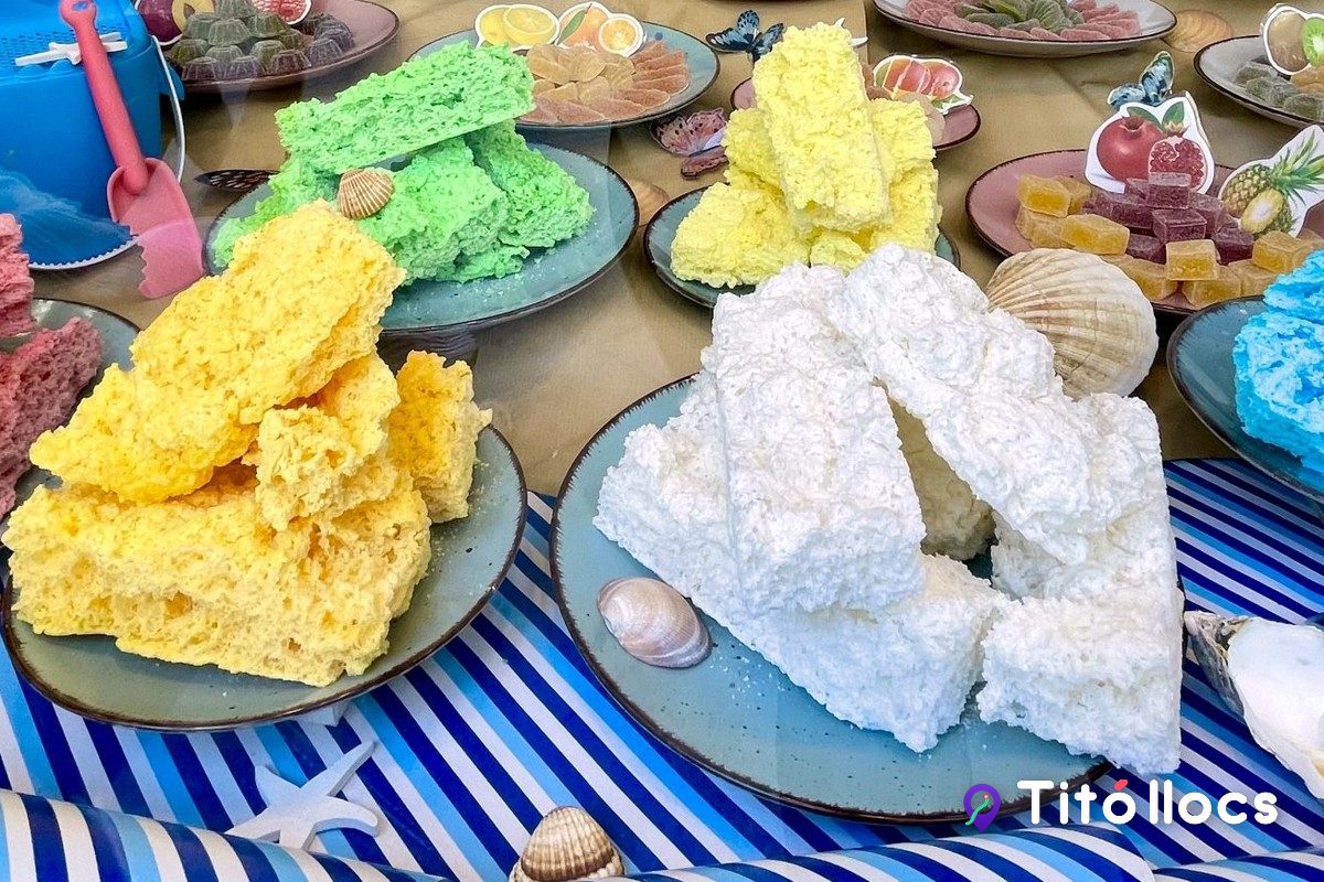 Dolços de colors, els bolados, servits en plats blaus a l'aparador, a Pastisseria La Colmena