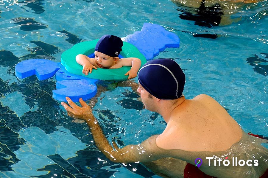 Monitor i nadó amb flotadors de colors al vas de clapoteig de la piscina Can Millars