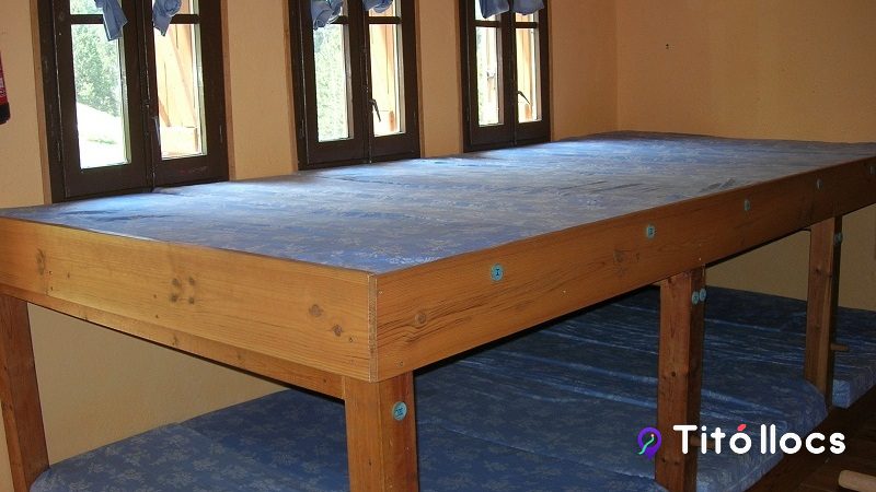 Dormitori del Refugi Pla de la Font amb lliteres i finestres.